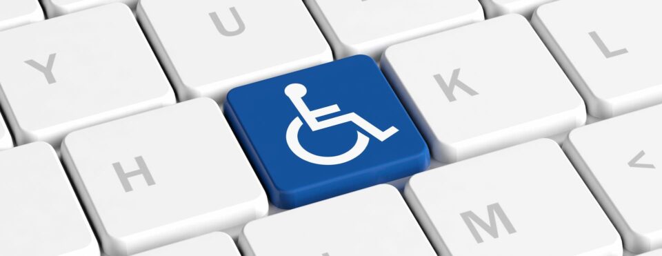 A close up of a keyboard but one of the keys have been replaced with a blue accessibility button